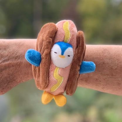 Adorable Penguin in a Hot Dog Costume Slap Bracelet. This cuddly friend easily wraps around your wrist, backpack, bedpost, or any object that fits its soft and snug embrace, PT101